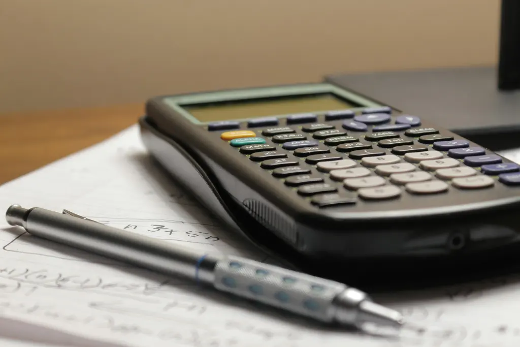 Calculadora y bolígrafo sobre unas hojas de cuentas