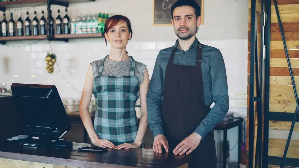 Dos personas que trabajan juntas detrás del mostrador de una cafetería