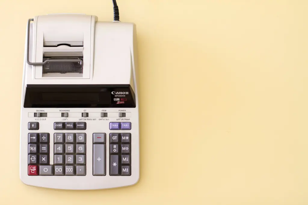 Calculadora con impresora de tiques sobre fondo amarillo claro